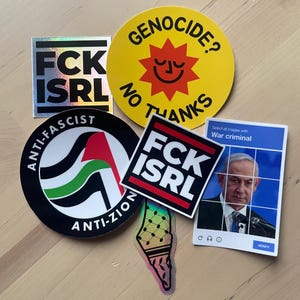 Op de afbeelding: Een verzameling stickers met diverse ontwerpen en boodschappen. Eén sticker leest "FCK ISRL" in vette letters. Een andere zegt "GENOCIDE? NO THANKS" met een lachende zon. Andere stickers bevatten "ANTI-FASCIST ANTI-ZION" en een afbeelding van een persoon met de tekst "War criminal".