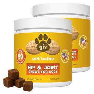 May include: Two yellow-labeled containers of dog chews with white lids. The label reads "HIP & JOINT CHEWS FOR DOGS" and "soft butter." The containers have a paw print logo and the text "MADE IN AMERICA." Several brown, square chews are in front.