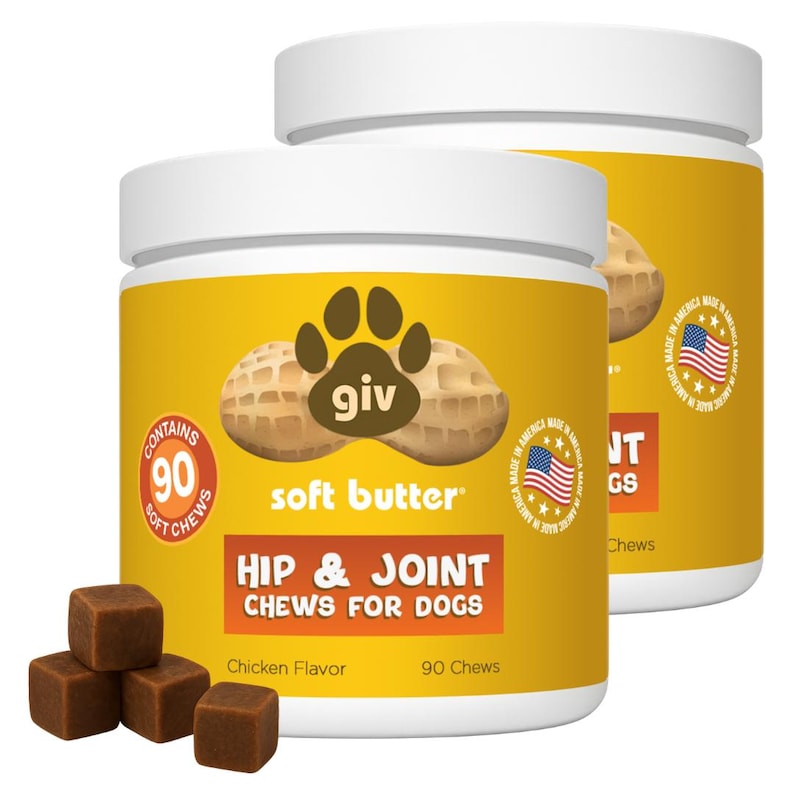 May include: Two yellow-labeled containers of dog chews with white lids. The label reads "HIP & JOINT CHEWS FOR DOGS" and "soft butter." The containers have a paw print logo and the text "MADE IN AMERICA." Several brown, square chews are in front.