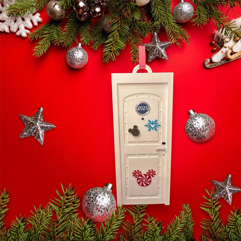 May include: A white decorative door ornament with the year 2025 on it, adorned with Mickey Mouse and snowflake designs. The ornament is surrounded by Christmas decorations, including ornaments, stars, and pine branches, all set against a red background.