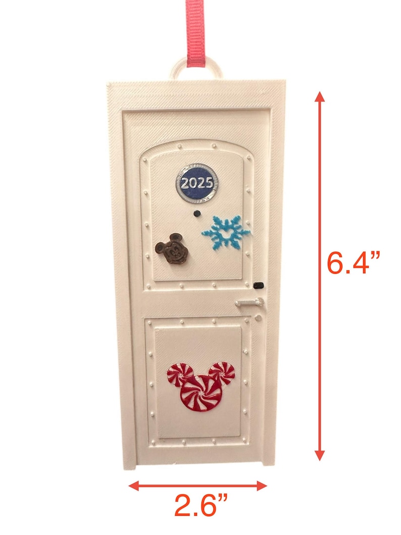 May include: White door-shaped ornament with a pink ribbon for hanging. The ornament features a Mickey Mouse head made of candy canes, a snowflake, and the year 2025. It measures 6.4 inches tall and 2.6 inches wide.