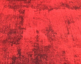 May include: Red fabric with a dark, mottled pattern. The fabric has a textured surface.
