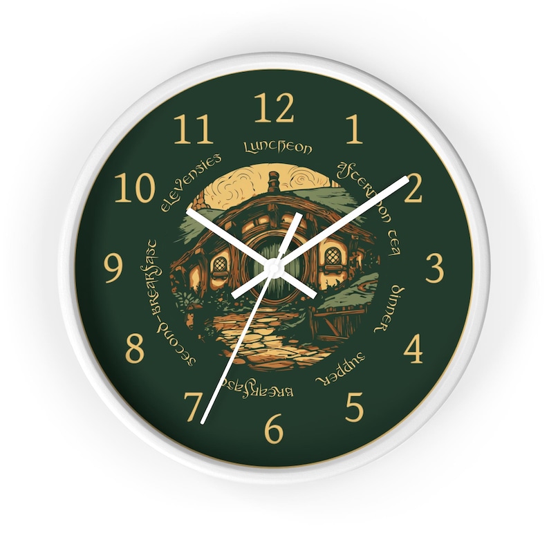 May include: A round wall clock with a white frame and a dark green face. The clock features gold numbers 1 through 12, white hands, and a central illustration of a round-door house. Text around the center reads: Breakfast, Second-Breakfast, Elevensies, Luncheon, Afternoon Tea, Dinner, Supper.