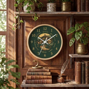May include: A round wall clock with a light wood frame and a dark green face. The clock features gold numbers one through twelve and a central illustration of a round-door house. Text around the center includes Breakfast, Second Breakfast, Elevenses, Luncheon, Afternoon Tea, Dinner, and Supper.