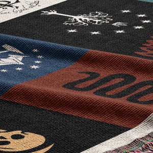 Close-up texture detail of Lord of the Rings Flags blanket showing woven fabric quality, magical symbols patchwork design with multicolored fringe detail