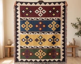 May include: A rectangular woven throw blanket featuring four horizontal bands in deep red, blue, yellow, and green. Each band displays repeating geometric cross patterns in contrasting colors. The blanket has a cream-colored border with a jagged edge.