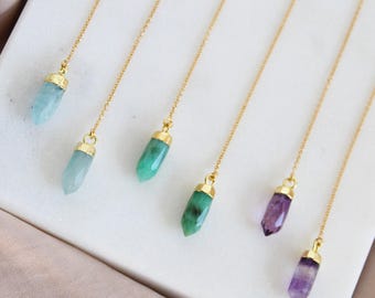 Peut inclure: Six colliers à chaîne dorée, chacun doté d'un pendentif en pierre précieuse facettée et pointue. Les pierres varient en couleur, incluant bleu clair, vert pâle, vert vif, vert foncé et deux nuances de violet, toutes serties de métal doré.