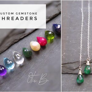 May include: Image of custom gemstone threaders. The image shows a selection of teardrop-shaped, faceted gemstones in various colours, including red, purple, blue, clear, green, yellow, and dark blue. A pair of green gemstone threader earrings is also shown.
