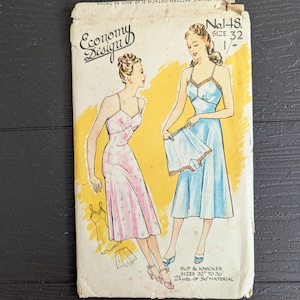 Può includere: Una busta per cartamodello vintage Economy Design, n. 148, taglia 32. L'illustrazione mostra due figure che indossano una sottoveste floreale rosa e una sottoveste blu con mutandine abbinate. Il testo include 'Economy Design', 'No. 148', 'Size 32'.