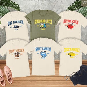 Puede incluir: Seis camisetas con dise&ntilde;os de personajes de la pel&iacute;cula Cars. Las camisetas son crema, verde oliva y blancas. Cada camiseta presenta el nombre de un personaje, la palabra "Cars" y el a&ntilde;o "2006". Los dise&ntilde;os incluyen Doc Hudson, Guido y Lucci, Lightning McQueen, Tow Mater, Sally Carrera y Cruz Ramirez.