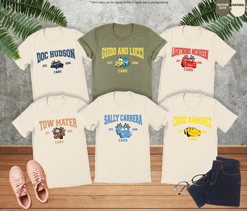 Puede incluir: Seis camisetas con dise&ntilde;os de personajes de la pel&iacute;cula Cars. Las camisetas son crema, verde oliva y blancas. Cada camiseta presenta el nombre de un personaje, la palabra "Cars" y el a&ntilde;o "2006". Los dise&ntilde;os incluyen Doc Hudson, Guido y Lucci, Lightning McQueen, Tow Mater, Sally Carrera y Cruz Ramirez.