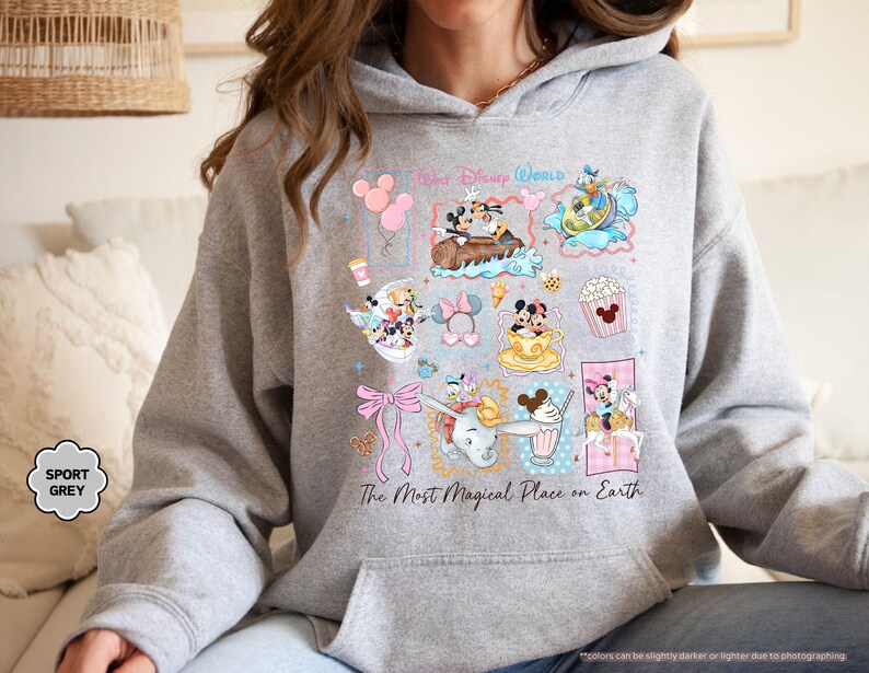 May include: Sport grey hoodie featuring a colorful collage of Disney characters and icons. The design includes Mickey and Minnie Mouse, Donald Duck, and Dumbo, with the text "Walt Disney World" and "The Most Magical Place on Earth".