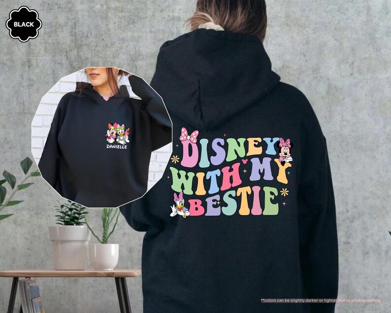 May include: Black hooded sweatshirt with a colorful graphic that says "Disney with my bestie" and features cartoon characters. The graphic also includes a pink bow, stars, and hearts.