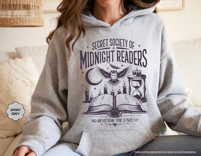 May include: Sport grey hoodie with a graphic that reads "SECRET SOCIETY OF MIDNIGHT READERS" with an owl, moon, candles, and an hourglass. The text "NO REST FOR THE UNREAD" is below the graphic.