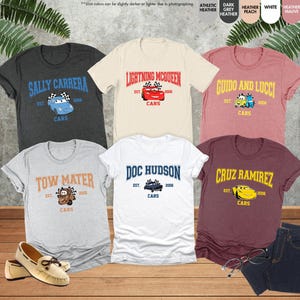 Puede incluir: Una colecci&oacute;n de camisetas de manga corta con personajes de la pel&iacute;cula animada "Cars". Cada camiseta muestra el nombre de un personaje, un gr&aacute;fico de coche y la palabra "Cars". Los colores incluyen gris, blanco, melocot&oacute;n y burdeos.
