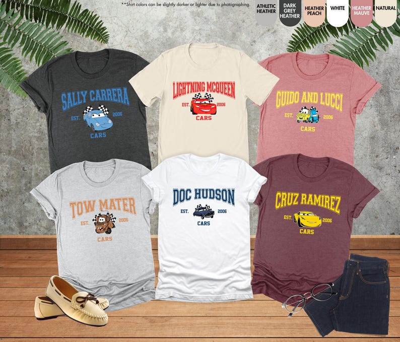 Puede incluir: Una colecci&oacute;n de camisetas de manga corta con personajes de la pel&iacute;cula animada "Cars". Cada camiseta muestra el nombre de un personaje, un gr&aacute;fico de coche y la palabra "Cars". Los colores incluyen gris, blanco, melocot&oacute;n y burdeos.