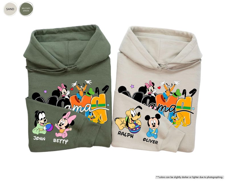 K&ouml;nnte beinhalten: Zwei Kapuzenpullover, einer in Milit&auml;rgr&uuml;n und einer in Sandfarbe, mit einer bunten Grafik von Disney-Figuren. Auf den Sweatshirts sind die W&ouml;rter "Mama" und Namen wie "John", "Betty", "Ralph" und "Oliver" aufgedruckt.