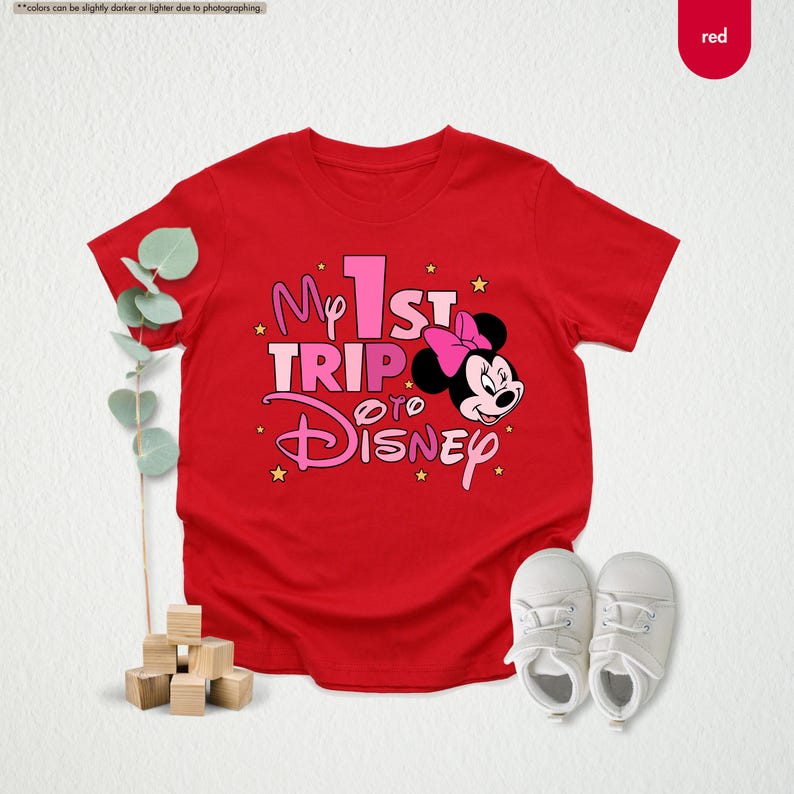 K&ouml;nnte beinhalten: Rotes T-Shirt mit einem pinkfarbenen Aufdruck von Mickey Mouse und dem Text "My 1st Trip to Disney".