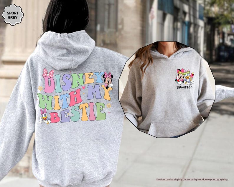 May include: A gray hoodie with a colorful "Disney with my bestie" graphic on the back and a smaller graphic of Disney characters on the front. The front graphic includes the text "Danielle".