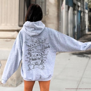 May include: A gray hooded sweatshirt with a black and white illustration of a flying machine on the back. The illustration is labeled with different parts of the machine.
