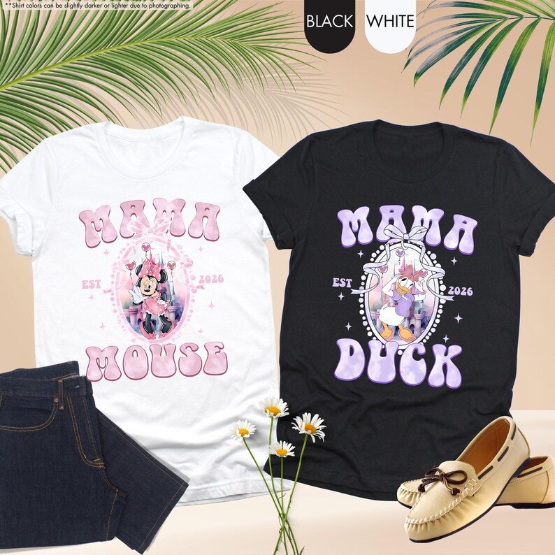 May include: Two t-shirts, one white and one black, with the text "MAMA" and a character graphic. The white shirt features Minnie Mouse, and the black shirt features Daisy Duck. Both shirts have "EST 2026" and the character's name below.