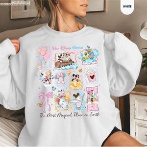 May include: White sweatshirt featuring colorful Disney character illustrations. The design includes Mickey and Minnie Mouse, Donald Duck, and Dumbo, with the text "Walt Disney World" and "The Most Magical Place on Earth."
