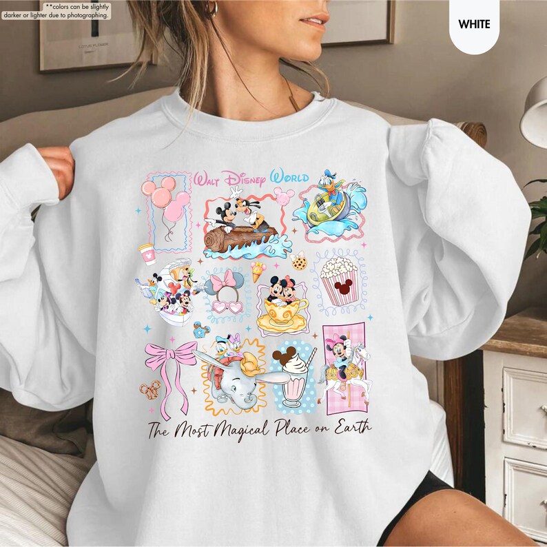 May include: White sweatshirt featuring colorful Disney character illustrations. The design includes Mickey and Minnie Mouse, Donald Duck, and Dumbo, with the text "Walt Disney World" and "The Most Magical Place on Earth."