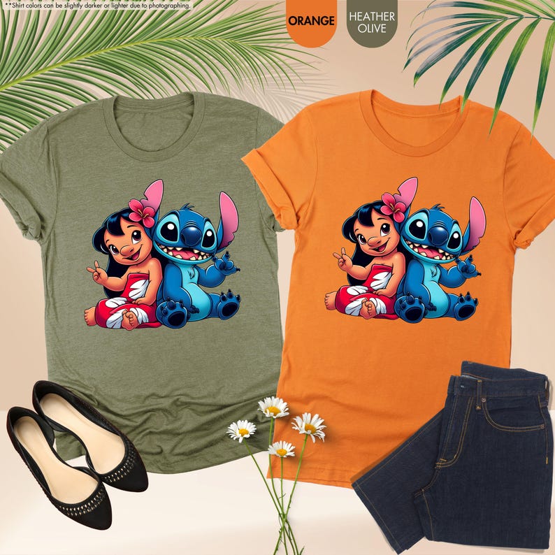 K&ouml;nnte beinhalten: Zwei T-Shirts, eines orangefarbenes und eines olivgr&uuml;nes, jeweils mit einer Cartoon-Grafik von Lilo und Stitch. Das orangefarbene Shirt wird mit dunkelblauen Jeans kombiniert. Schwarze Ballerinas und G&auml;nsebl&uuml;mchen sind ebenfalls im Bild.