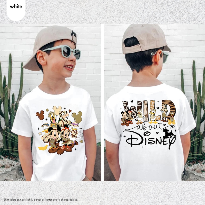 May include: White t-shirt featuring a Disney-themed design. The front displays Mickey and Minnie Mouse with other characters. The back of the shirt has the text "WILD about Disney" with character illustrations. The shirt is worn by a child.