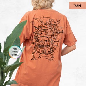 Puede incluir: Una camiseta naranja quemada con un dibujo en l&iacute;nea negra de una m&aacute;quina voladora en la espalda. El dibujo est&aacute; etiquetado con detalles como "Watchtower", "Discharge pipe", "Halix direction", "Develling house", "Stabilizer Legs", "Secondary propeller" y "Wings".