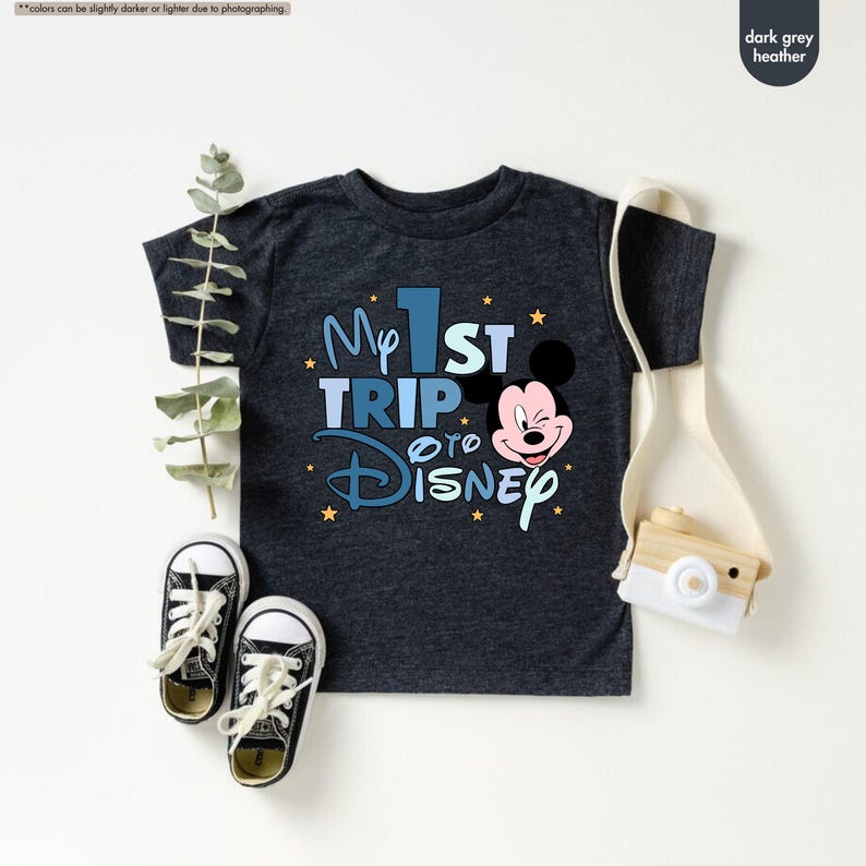 K&ouml;nnte beinhalten: Dunkelgraues T-Shirt mit Melange-Effekt mit einem blauen und wei&szlig;en Aufdruck, der "My 1st Trip to Disney" mit einem Comic-Mickey-Mouse-Kopf zeigt.