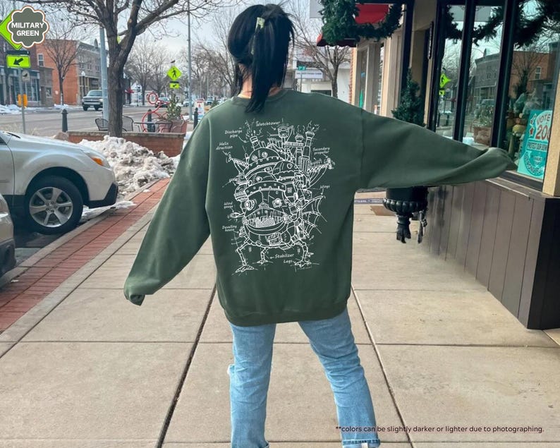 May include: A green sweatshirt with a white graphic print of a flying machine with the text "Howl's Moving Castle" on the back.