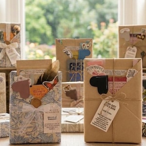 May include: Multiple rectangular gift packages wrapped in brown kraft paper or patterned floral paper, tied with twine or ribbon, and decorated with small paper cutouts, stickers, feathers, and tags labeled with text like Blind Date with a Book.