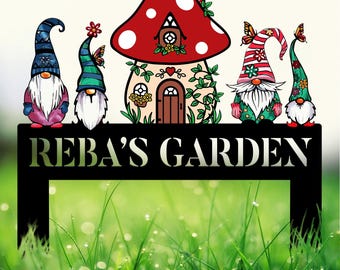 May include: A metal garden sign with the words "REBA'S GARDEN" in white lettering. The sign features a mushroom house with a red and white top and a green vine design. There are four gnomes, two with red hats, one with a blue hat, and one with a green hat.