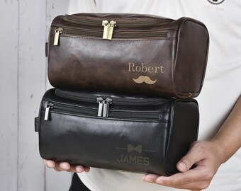 May include: Two brown leather travel bags with zips. The top bag has the name "Robert" and a moustache design. The bottom bag has the name "James" and a bow tie design.