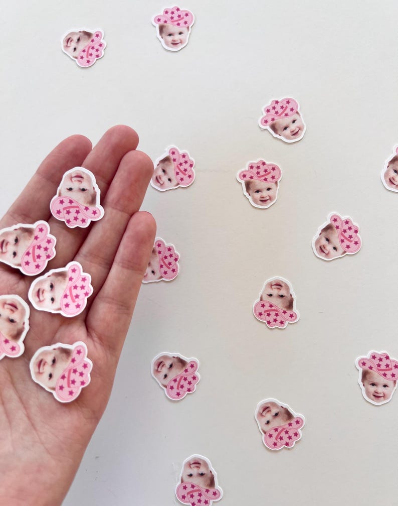 Op de afbeelding: Een witte achtergrond met roze en witte confetti met daarop een babygezicht met een roze cowboyhoed met roze sterren.
