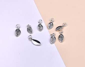 May include: A collection of eight silver leaf charms, some with a textured design, perfect for jewelry making or crafting projects.