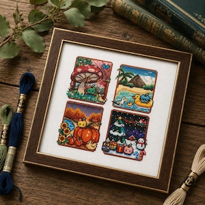 May include: A framed cross-stitch sampler featuring four distinct seasonal scenes: a spring mushroom forest, a summer beach with a rubber duck, an autumn pumpkin patch with sunflowers, and a winter holiday scene with a tree, gifts, and a snowman.