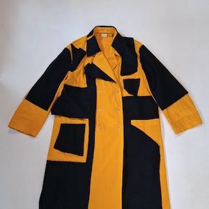 May include: A long yellow and black patchwork coat with a double breasted closure and large pockets.