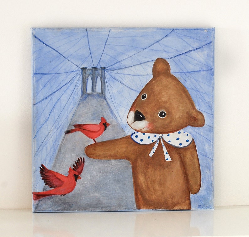 May include: A whimsical painting of a brown bear with a blue and white polka-dot collar, interacting with two red cardinals. The background features a bridge and blue lines, creating a charming and imaginative scene.