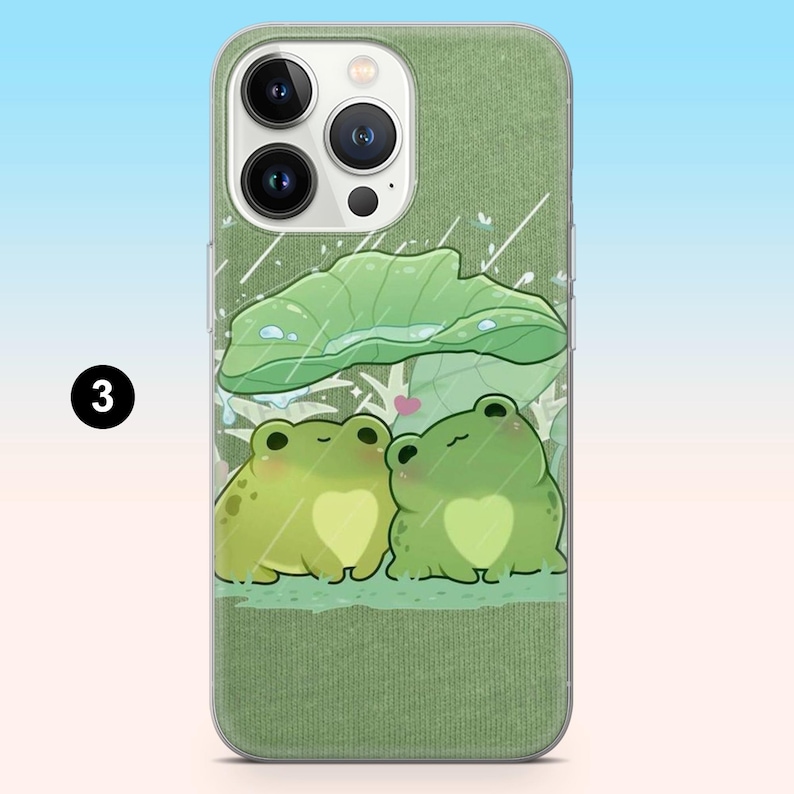 May include: Green phone case featuring a cartoon illustration of two frogs under a large leaf, with raindrops and a heart. The case has a textured green background and a clear border. The number "3" is in a black circle.