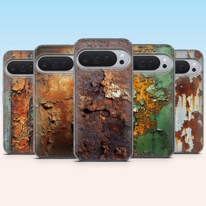Peut inclure: Cinq coques de téléphone avec une texture de métal rouillé et vieilli. Les coques présentent une variété de couleurs, notamment orange, marron, vert et bleu, avec de la peinture écaillée et du métal apparent. Les coques sont disposées en rangée sur un fond bleu clair.