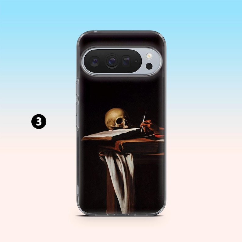 May include: A clear phone case featuring a painting of a skull, a hand holding a pen, and a book on a table. The artwork has a dark background with a white cloth draped over the table.