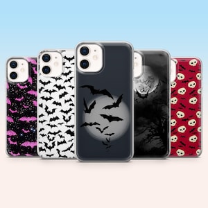 May include: A collection of phone cases with Halloween-themed designs. The cases feature patterns of bats, skulls, and a full moon with bats. Colors include black, white, red, and pink. The cases are designed to fit a smartphone.