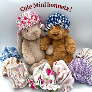 May include: A collection of mini bonnets in various floral and patterned fabrics. Two stuffed animals, a bunny and a bear, wear bonnets. The bonnets feature designs with strawberries, cherries, and gingham patterns. The text "Cute Mini bonnets!" is at the top.