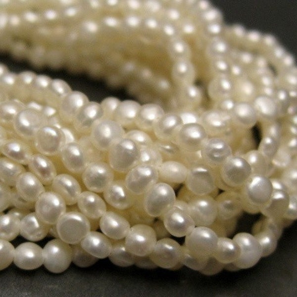 2 - 2.5 mm creamy white ( ivory ) button cultured freshwater seed pearls--one 16 inch strand