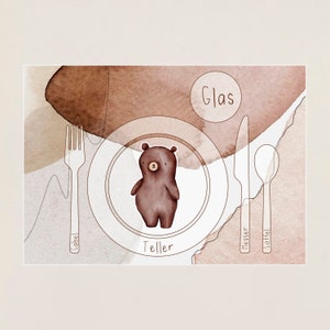 Könnte beinhalten: Eine Aquarellillustration einer Tischdekoration mit einem braunen Bären in der Mitte des Tellers. Die Wörter "Gabel", "Messer", "Löffel", "Teller" und "Glas" stehen um die Tischdekoration herum.