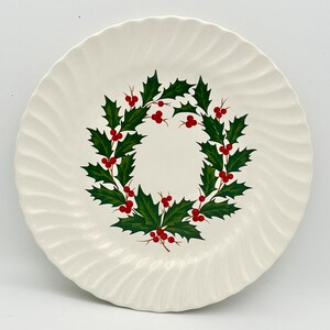 May include: White ceramic plate with a green holly wreath and red berries design.