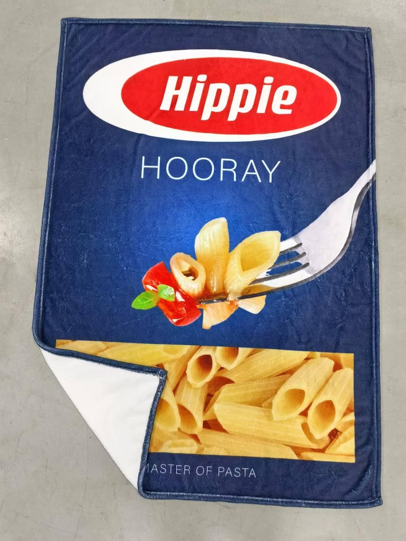 May include: A blue and yellow box with the words "Hippie Hooray" and "Master of Pasta" printed on it. The box features a picture of pasta on a fork with a red pepper and basil.