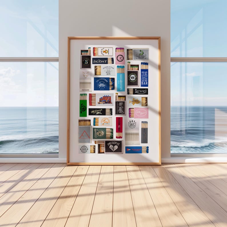 May include: A framed collage of matchbox labels featuring various designs and logos. The labels are arranged in a grid pattern and include names like "The Goat", "Dry 85", "Level", and "The Preserve".